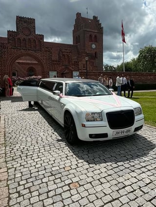 Hvid Chrysler limousine foran kirke til bryllup